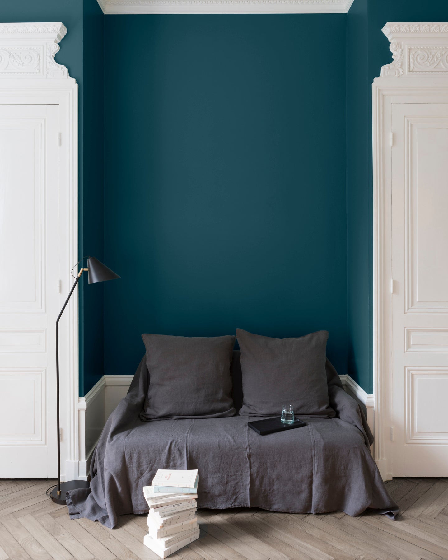 Salon aux murs bleus, peinture Velours de Peinture Bleu d'Auvergne Libéron avec portes blanches et textiles gris.