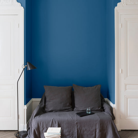 Salon aux murs bleus, peinture Velours de Peinture Bleu d'Iroise Libéron avec portes blanches et textiles gris.