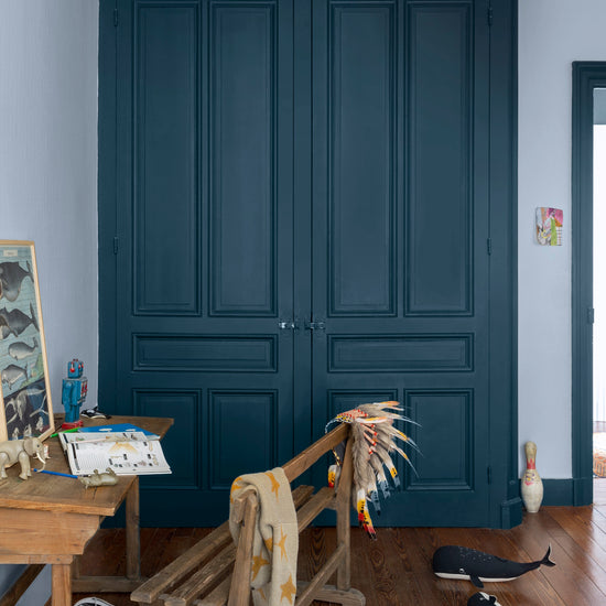 Armoire aux portes bleues, peinture Velours de Peinture Bleu de Minuit Libéron, murs blancs et mobilier en bois.