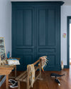 Armoire aux portes bleues, peinture Velours de Peinture Bleu de Minuit Libéron, murs blancs et mobilier en bois.