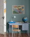 Coin bureau aux murs bleu Neptune Libéron, avec secrétaire bleu, chaise en bois, globe et affiche encadrée.