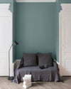 Salon aux murs bleu Neptune, Velours de Peinture Libéron, avec canapé gris, portes blanches et parquet clair.