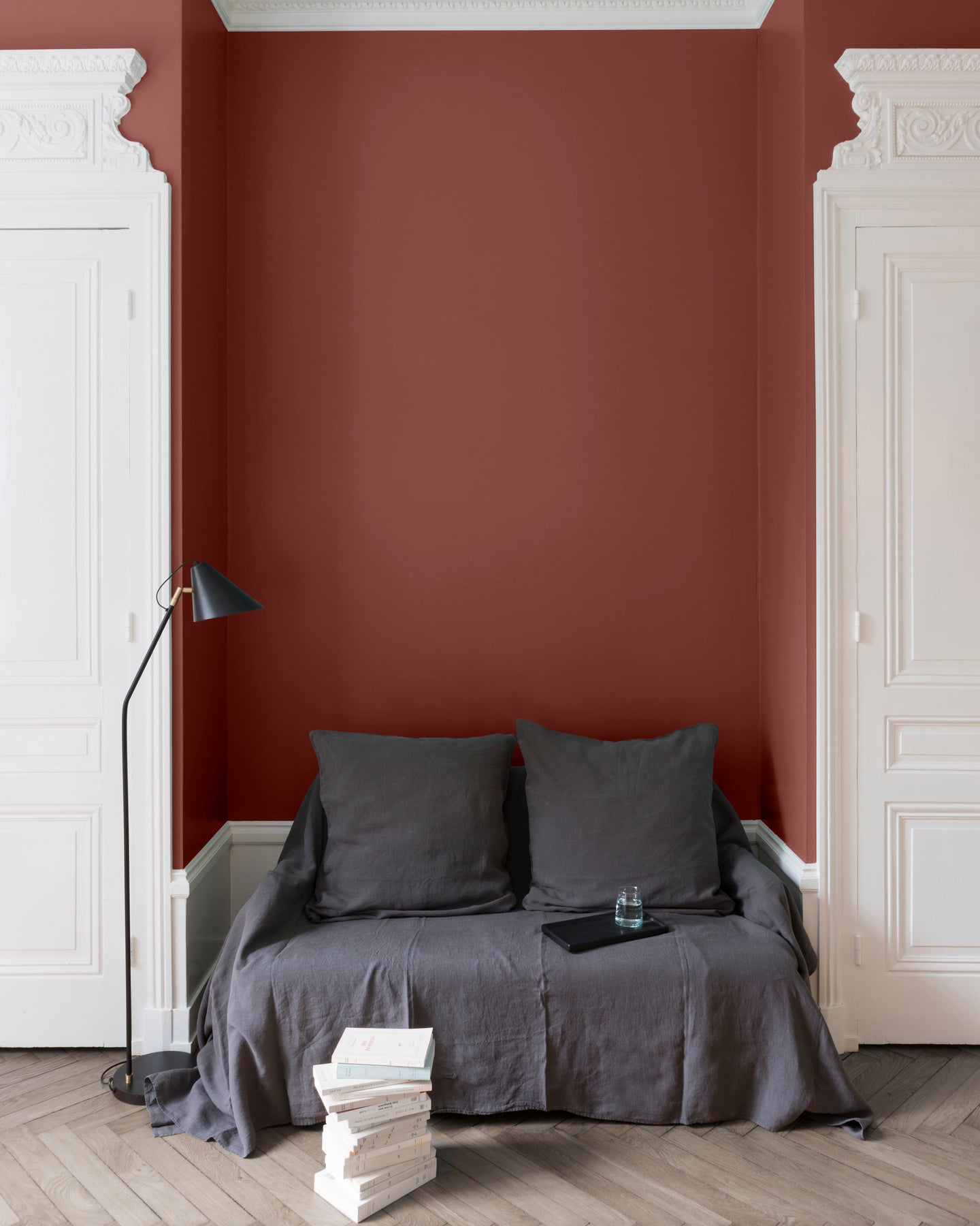 Salon aux murs blancs, peinture Velours de Peinture Brique Provençale Libéron, avec portes blanches et textiles gris.