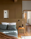 Chambre ambiance chaleureuse aux murs bruns, peinture Velours de Peinture Bronze Astrolabe Libéron, avec parquet et mobilier en bois