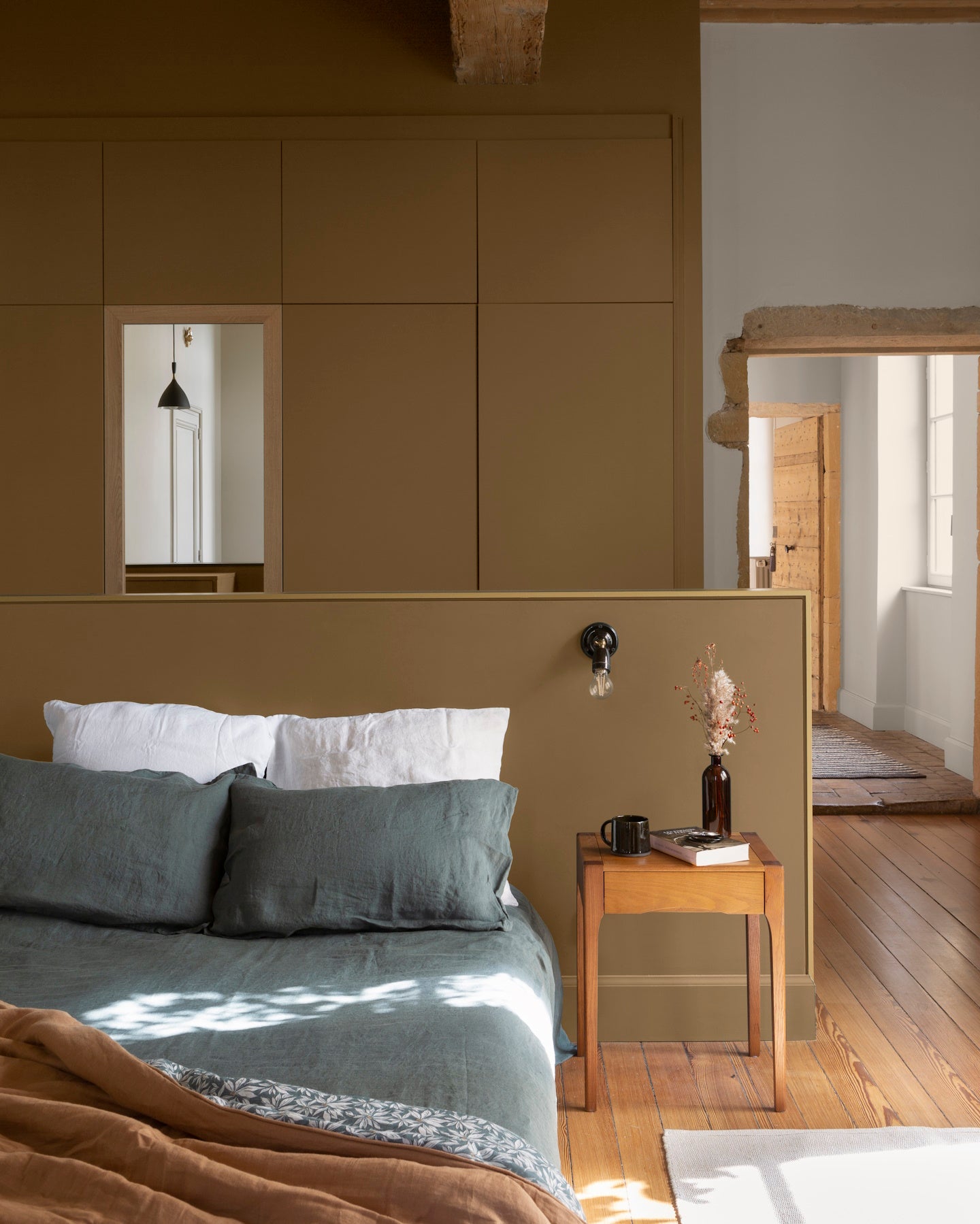 Chambre ambiance chaleureuse aux murs bruns, peinture Velours de Peinture Bronze Astrolabe Libéron, avec parquet et mobilier en bois