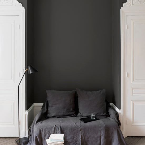 Salon aux murs Brun Caviar, Velours de Peinture Libéron, avec canapé gris, portes blanches et parquet clair.