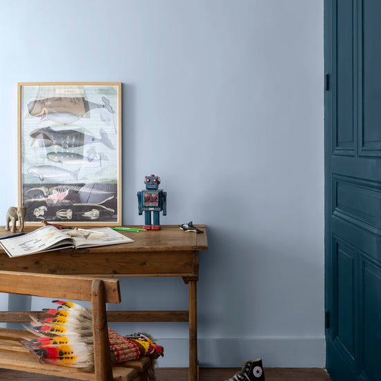 Chambre d'enfant aux murs bleus, peinture Velours de Peinture Cap Blanc-Nez Libéron, avec armoire bleu foncé et bureau en bois
