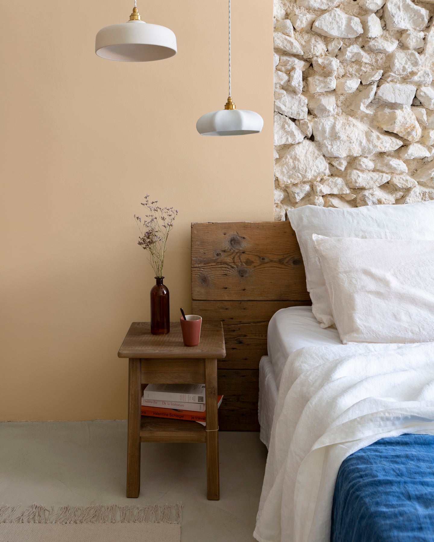 Chambre aux murs confiture de lait, Velours de Peinture Libéron, avec tête de lit en bois et linge blanc.