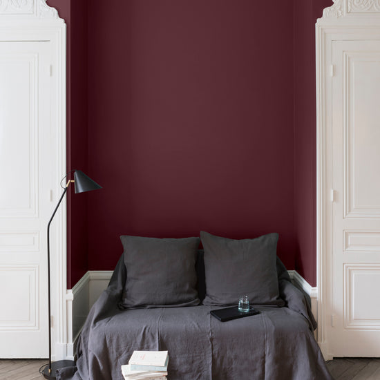 Salon aux murs rouges, peinture Velours de Peinture Coq au Vin Libéron avec portes blanches et textiles gris.