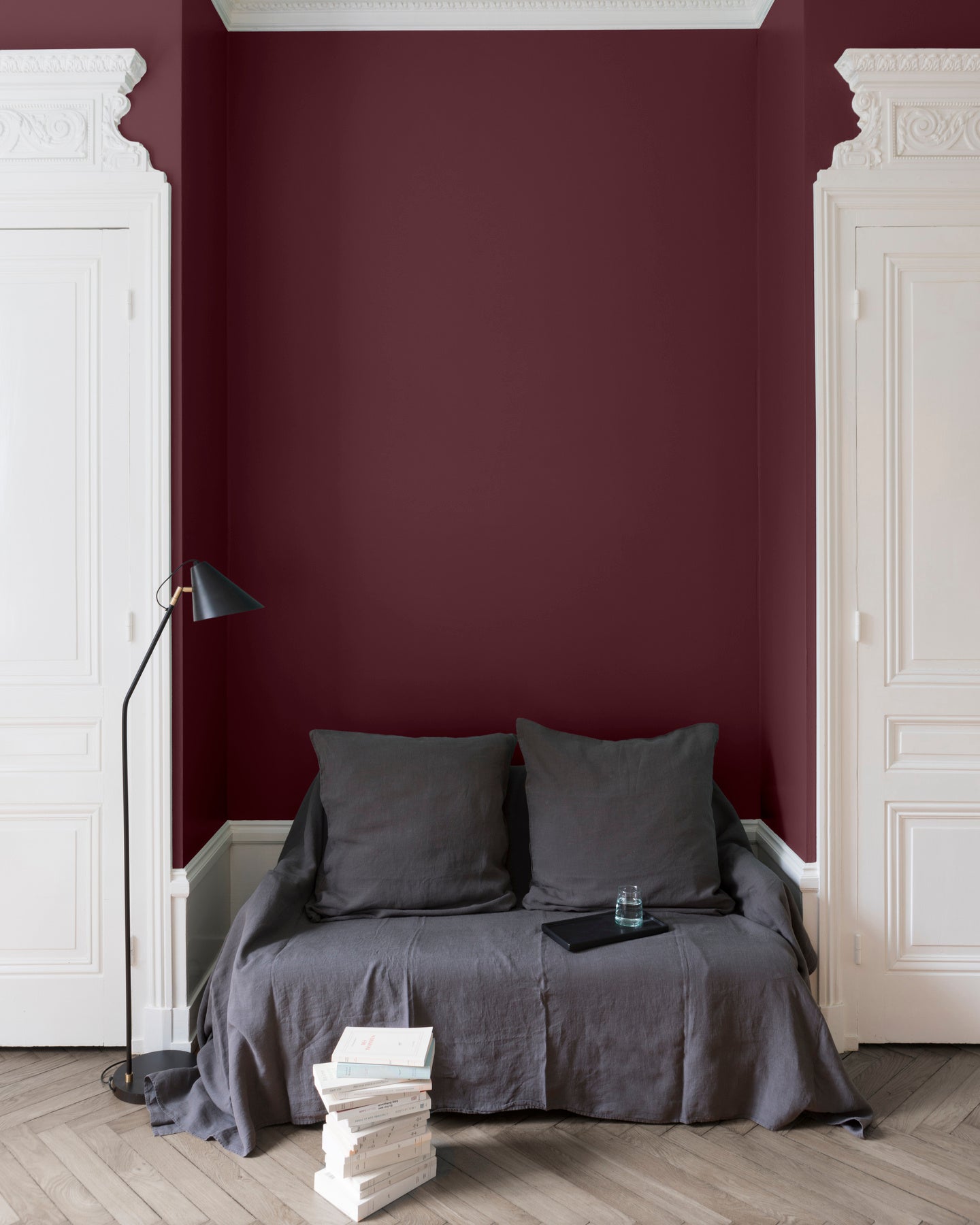 Salon aux murs rouges, peinture Velours de Peinture Coq au Vin Libéron avec portes blanches et textiles gris.