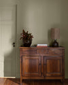 Pièce avec murs verts, peinture Velours de Peinture Crème d'Artichaut Libéron, avec porte verte, commode en bois et parquet