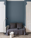 Salon aux murs bleus, peinture Velours de Peinture Fine de Claire Libéron avec portes blanches et textiles gris.