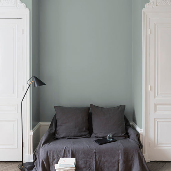 Salon aux murs gris, peinture Velours de Peinture Grès Gris Libéron avec portes blanches et textiles gris.