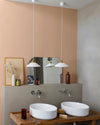 Salle de bain lumineuse avec murs roses, peinture Velours de Peinture Grès Rose Libéron, muret gris et deux vasques blanches