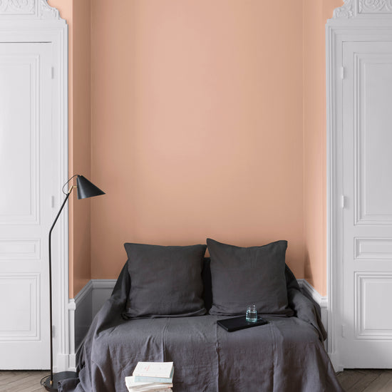 Salon aux murs Grès Rose, Velours de Peinture Libéron, avec canapé gris, portes blanches et parquet clair.