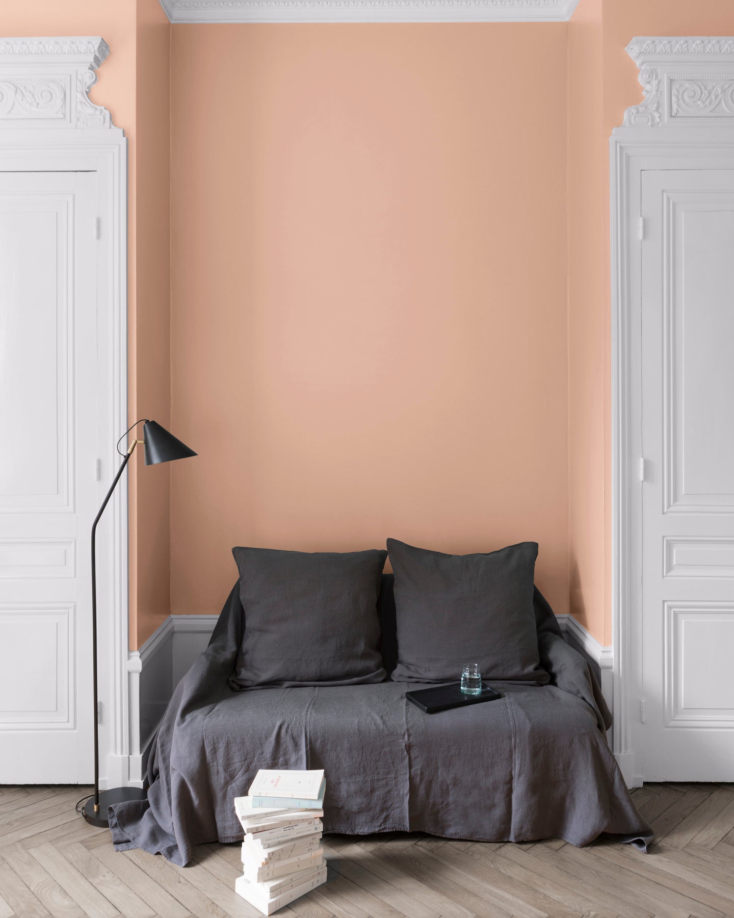 Salon aux murs Grès Rose, Velours de Peinture Libéron, avec canapé gris, portes blanches et parquet clair.
