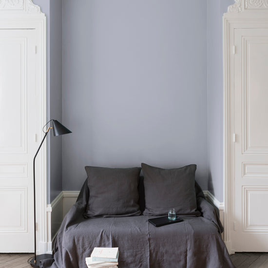 Salon aux murs gris, peinture Velours de Peinture Gris Conserverie Libéron avec portes blanches et textiles gris.