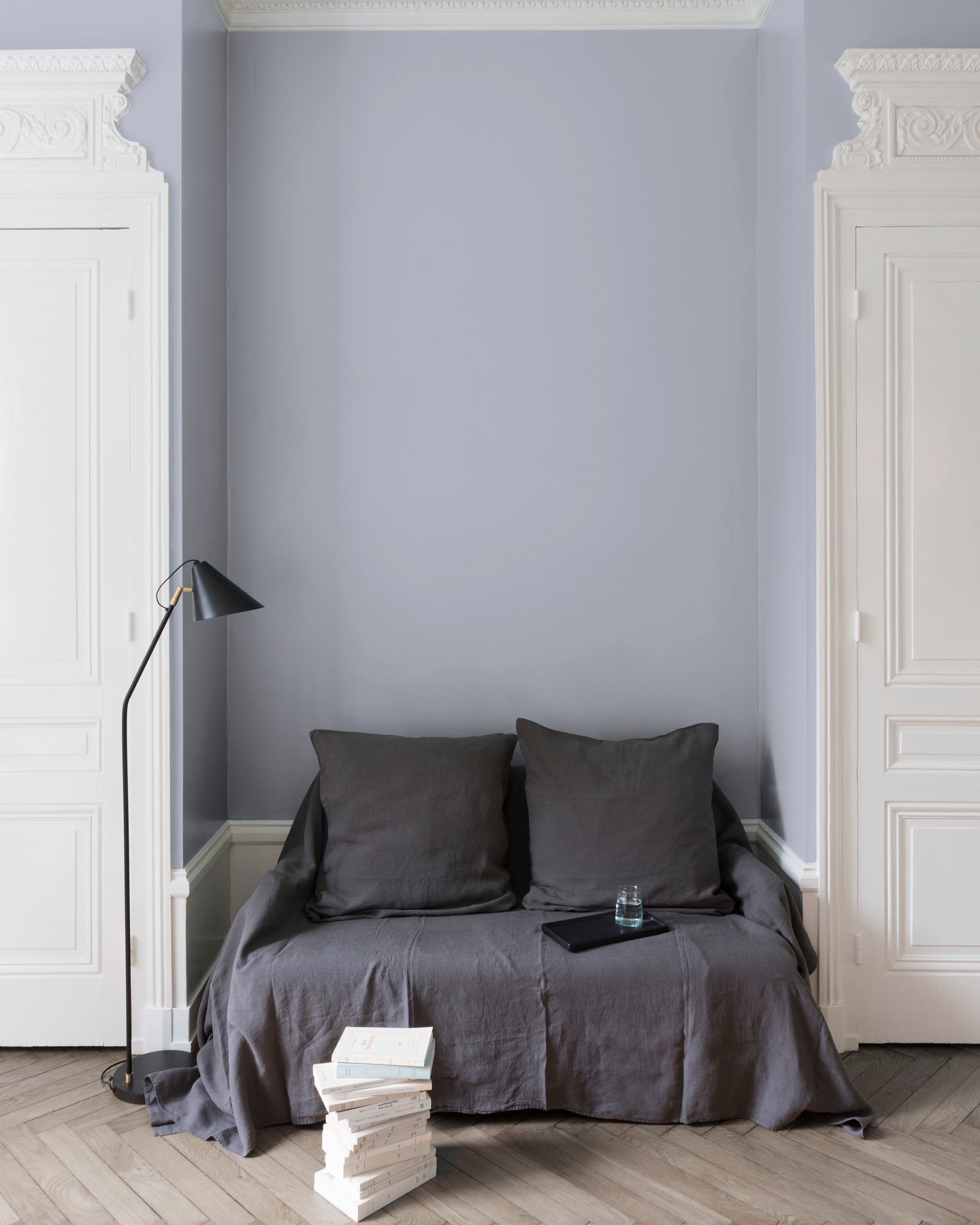 Salon aux murs gris, peinture Velours de Peinture Gris Conserverie Libéron avec portes blanches et textiles gris.