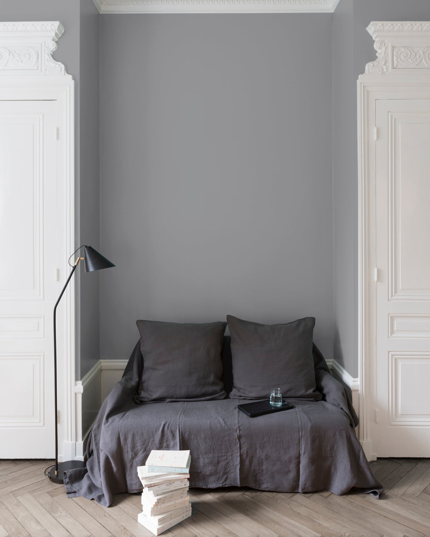 Salon aux murs gris, peinture Velours de Peinture Gris Corne de Brume Libéron avec portes blanches et textiles gris.