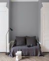 Salon aux murs Gris Corne de Brume Velours de Peinture Libéron, avec canapé gris, portes blanches, lampadaire noir et parquet clair.