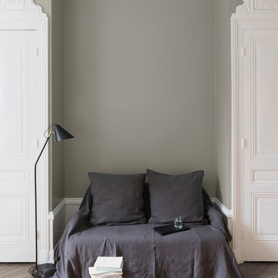 Salon aux murs gris, peinture Velours de Peinture Gris des Marais Libéron avec portes blanches et textiles gris.