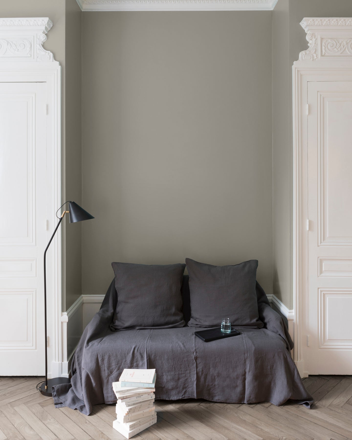 Salon aux murs gris, peinture Velours de Peinture Gris des Marais Libéron avec portes blanches et textiles gris.