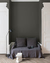 Salon aux murs gris fer forgé Libéron, avec canapé gris, portes blanches, lampadaire noir et parquet clair.