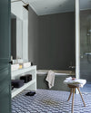 Salle de bain ambiance moderne aux murs gris, peinture Velours de Peinture Gris Fer Forgé Libéron, avec sol à motifs et vasques blanches