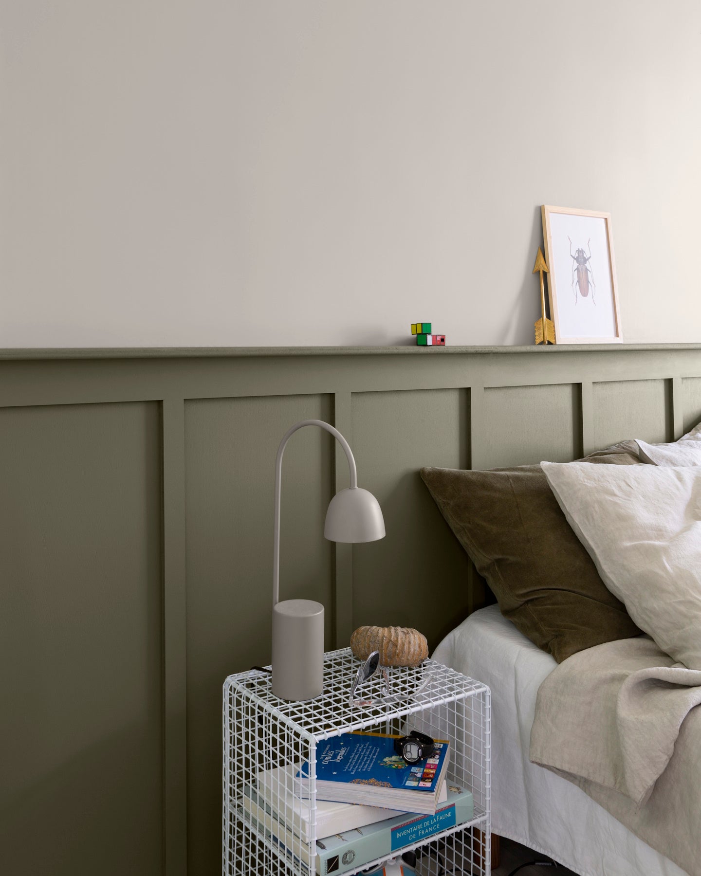 Chambre aux murs crème topinambour et gris gavroche Libéron, avec tête de lit peinte, linge beige et lampe grise.