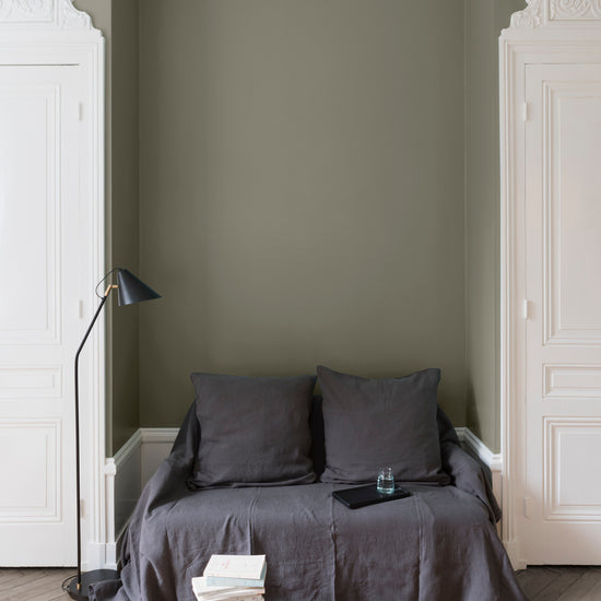 Salon aux murs Gris Gavroche, Velours de Peinture Libéron, avec canapé gris, portes blanches et parquet clair.