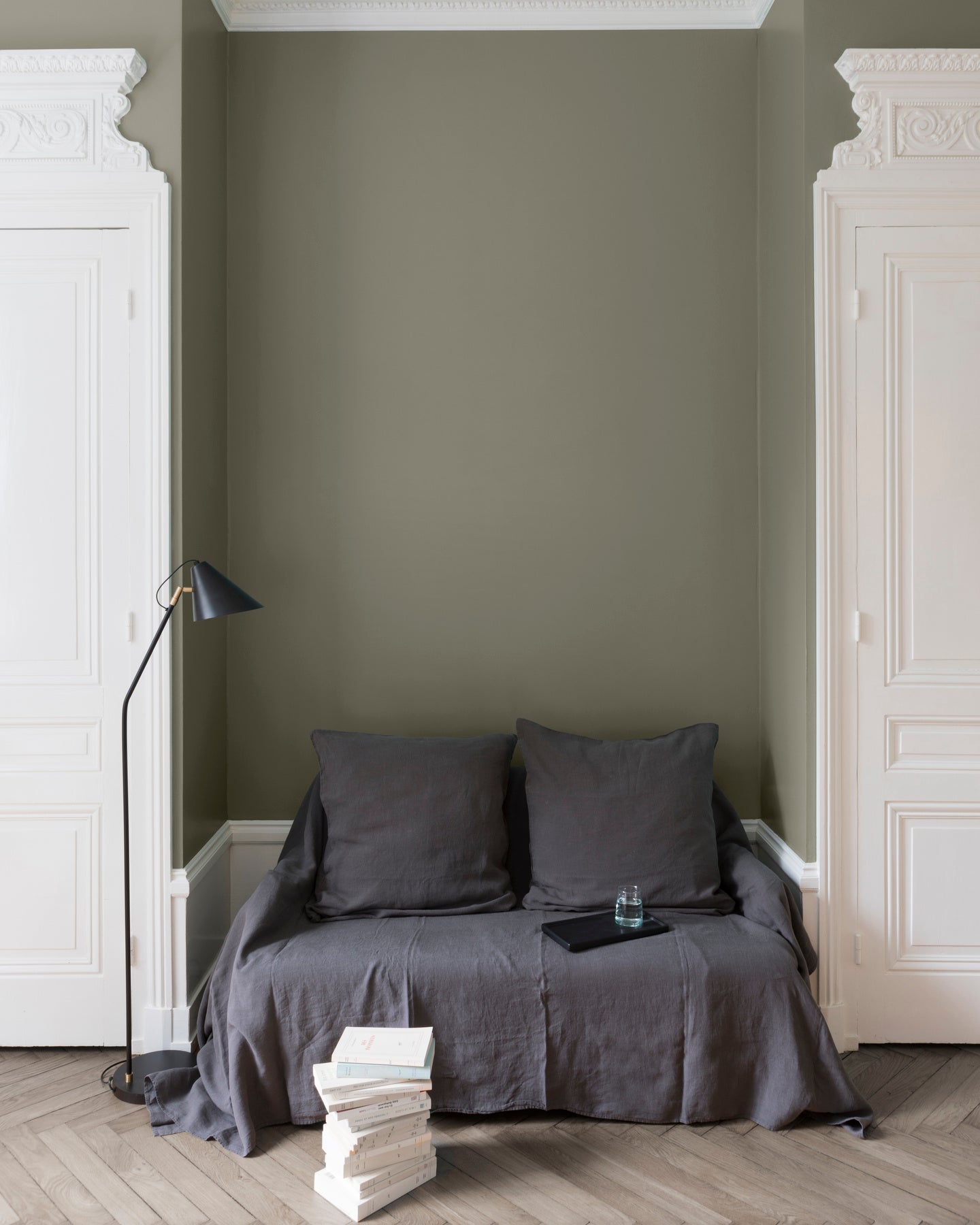 Salon aux murs Gris Gavroche, Velours de Peinture Libéron, avec canapé gris, portes blanches et parquet clair.