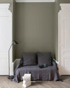 Salon aux murs gris gavroche Libéron, avec canapé gris, portes blanches, lampadaire noir et parquet clair.