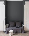 Salon aux murs Gris Gravure Libéron, avec canapé gris, portes blanches, lampadaire noir et parquet clair.