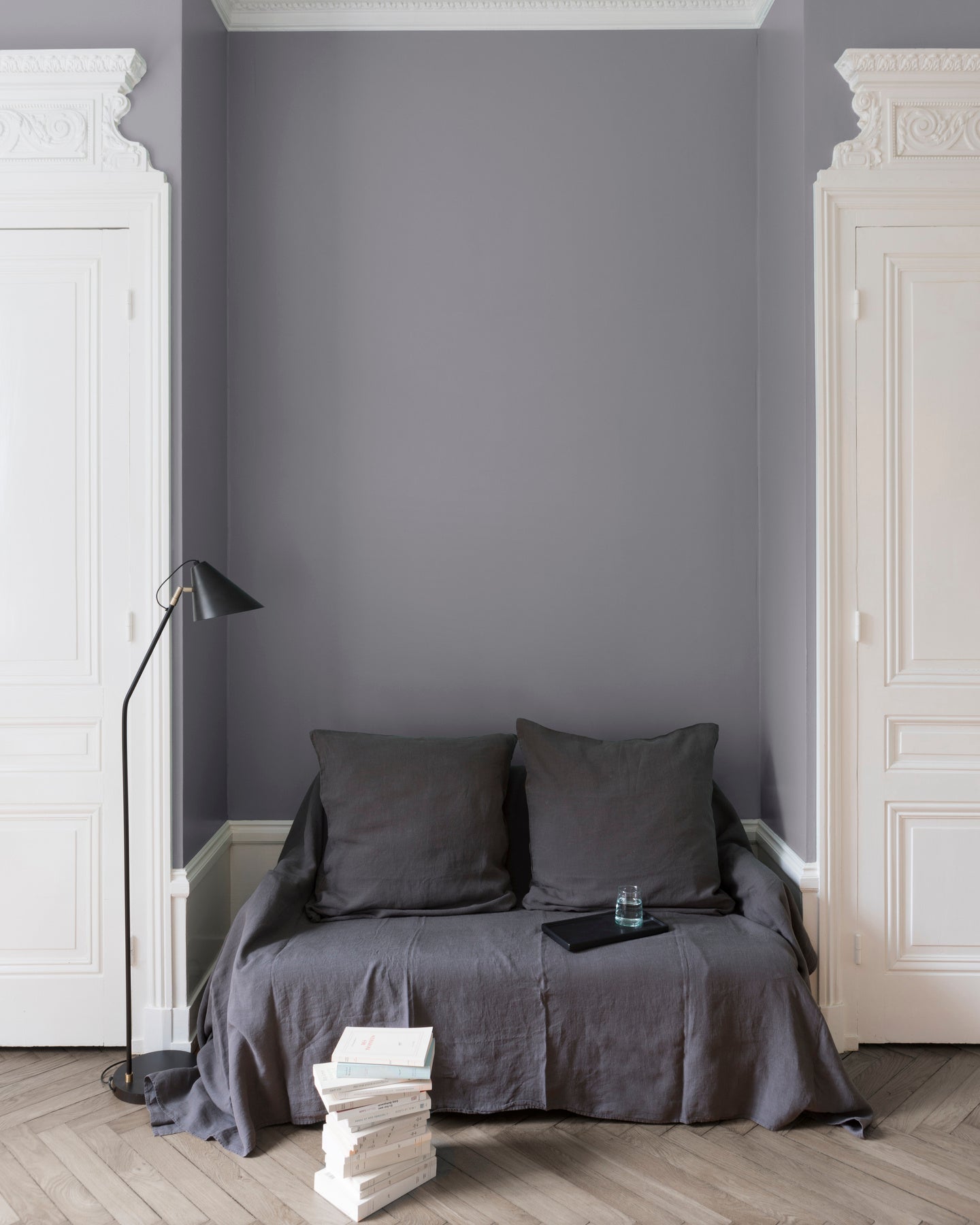 Salon aux murs Gris Gustave III, Velours de Peinture Libéron, avec canapé gris, portes blanches et parquet clair.