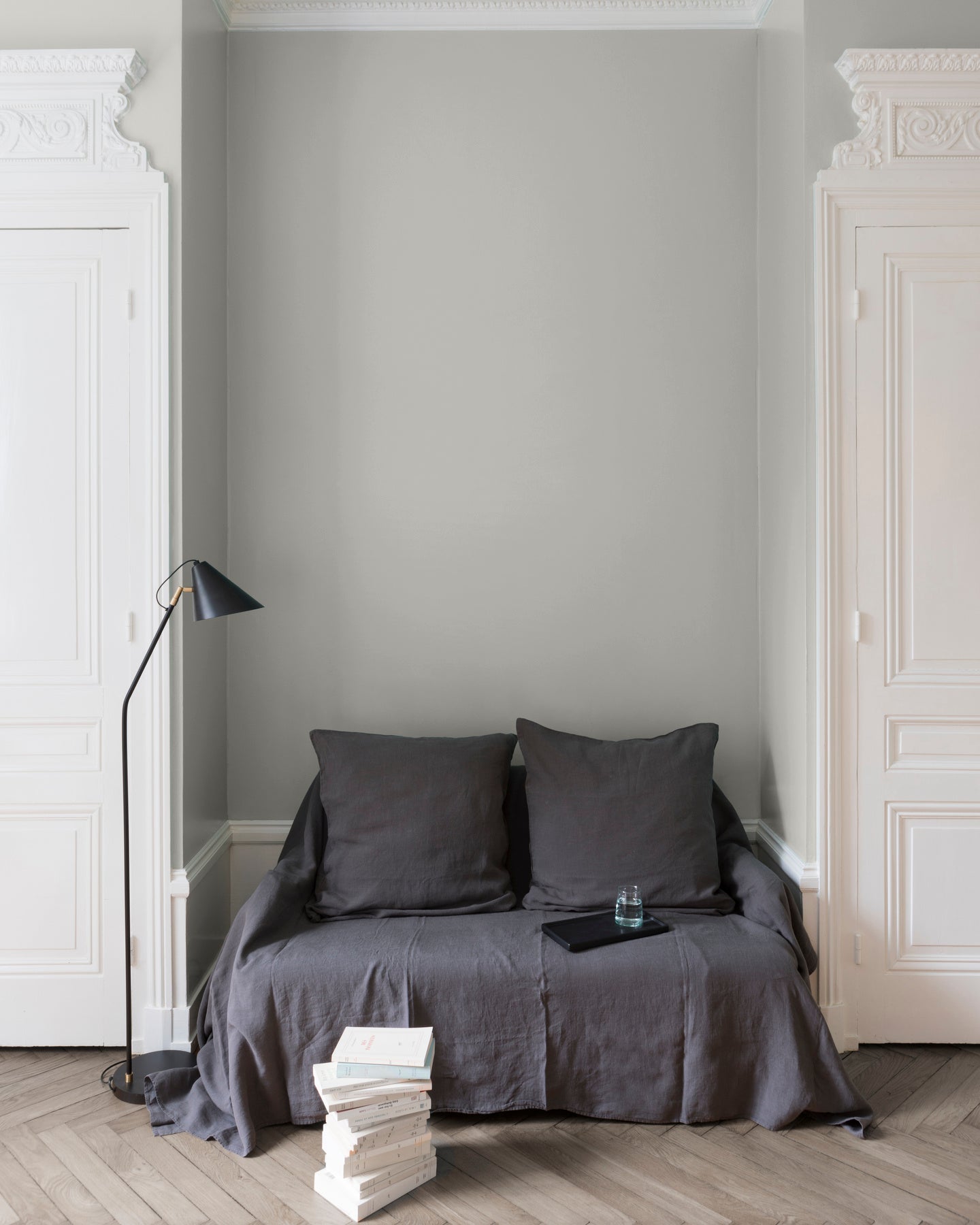 Salon aux murs blancs, peinture Velours de Peinture Gris Pleurote Libéron, avec portes blanches et textiles gris.