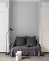 Salon aux murs Gris Sarrazin, Velours de Peinture Libéron, avec canapé gris, portes blanches et parquet clair.