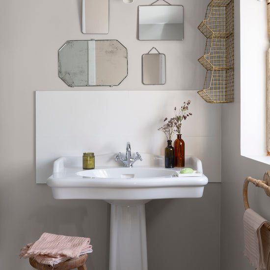 Salle de bain lumineuse avec murs gris, peinture Velours de Peinture Gris Saunier Libéron, vasque blanche et petits miroirs