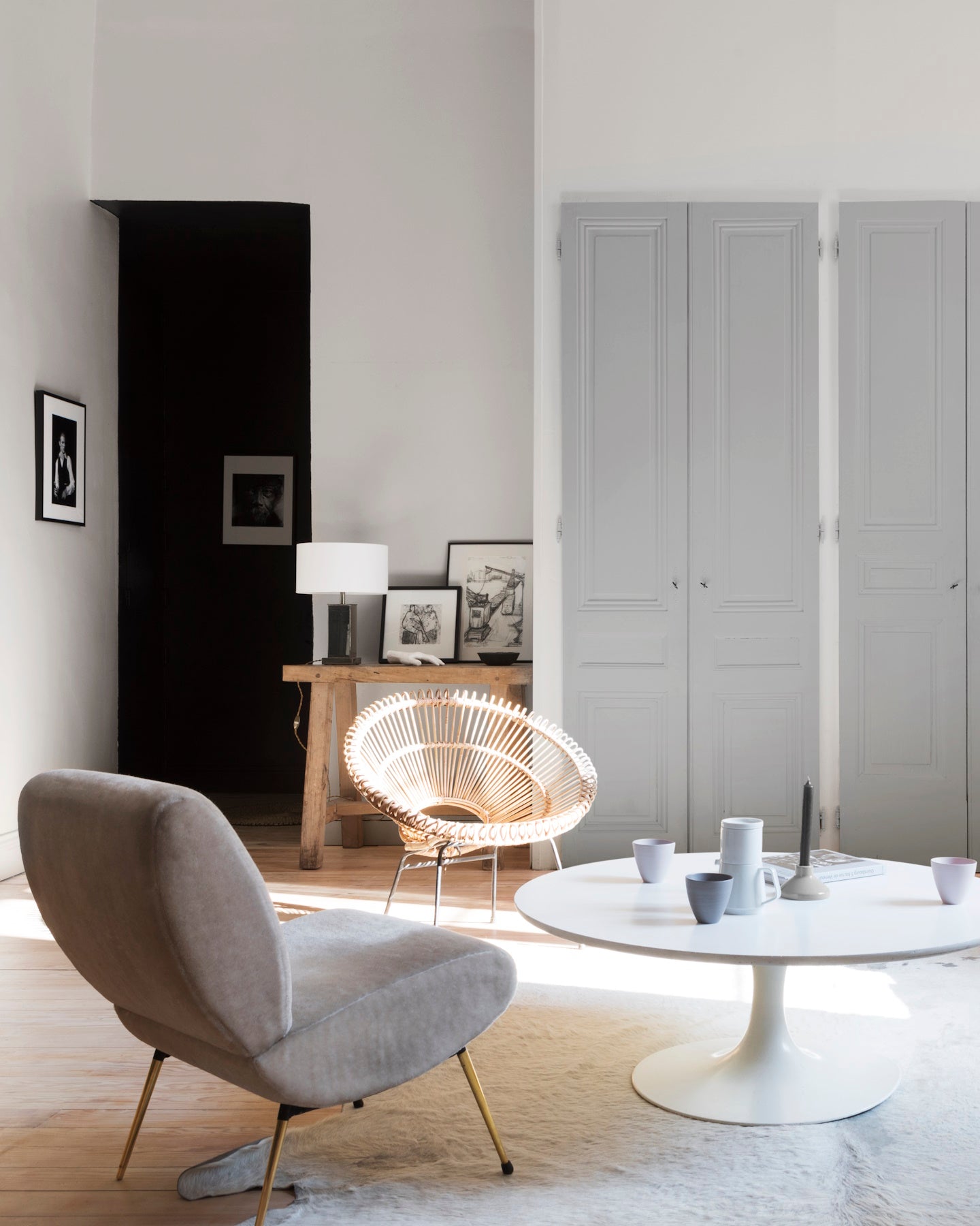 Salon aux murs gris temps de pluie et gris sarrazin Libéron, avec fauteuil gris, table blanche et portes de placard peints.