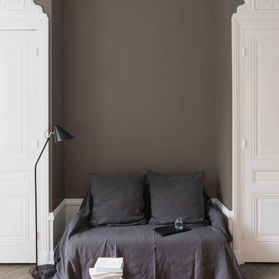 Salon aux murs Gris Vison, Velours de Peinture Libéron, avec canapé gris, portes blanches et parquet clair.