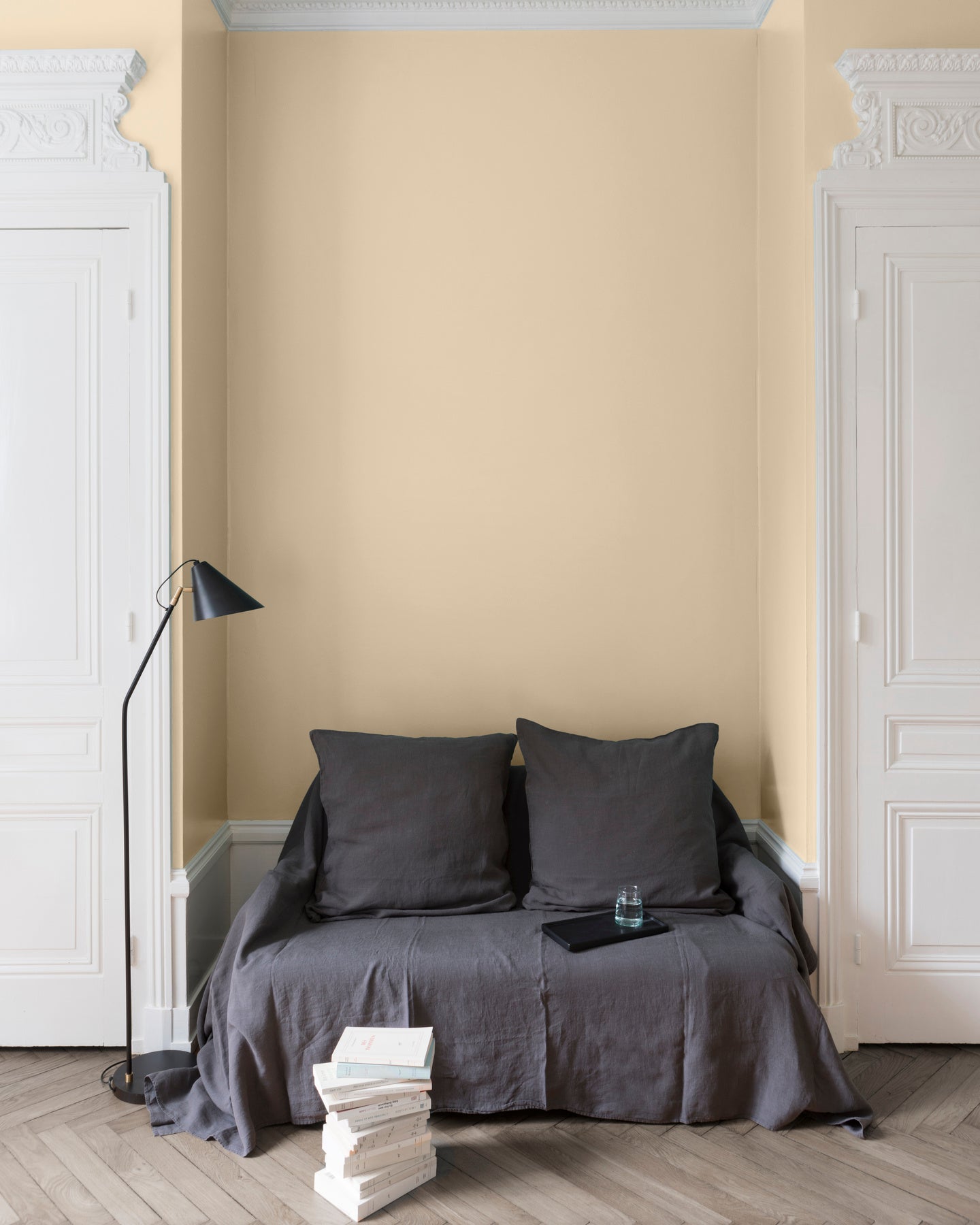 Salon aux murs Jaune Sabayon, Velours de Peinture Libéron, avec canapé gris, portes blanches et parquet clair.