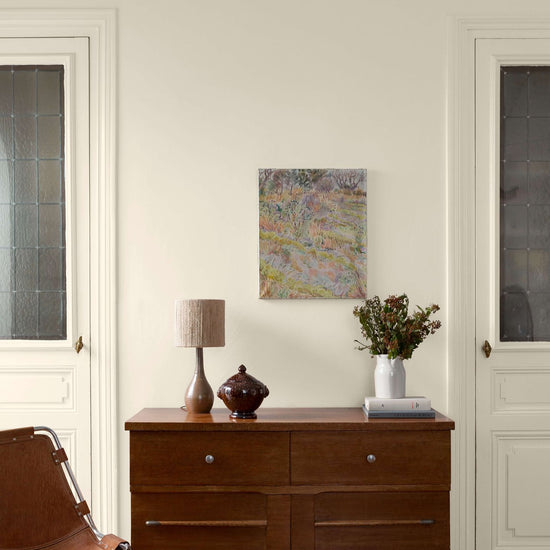 Salon avec une commode en bois, des murs et des portes peintes avec la peinture Libéron Velours de Peinture, teinte Monnaie du Pape.