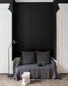 Salon aux murs noirs, peinture Velours de Peinture Noir Smoking Libéron avec portes blanches et textiles gris.