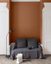 Salon aux murs oranges, peinture Velours de Peinture Pain d'Épices Libéron avec portes blanches et textiles gris.