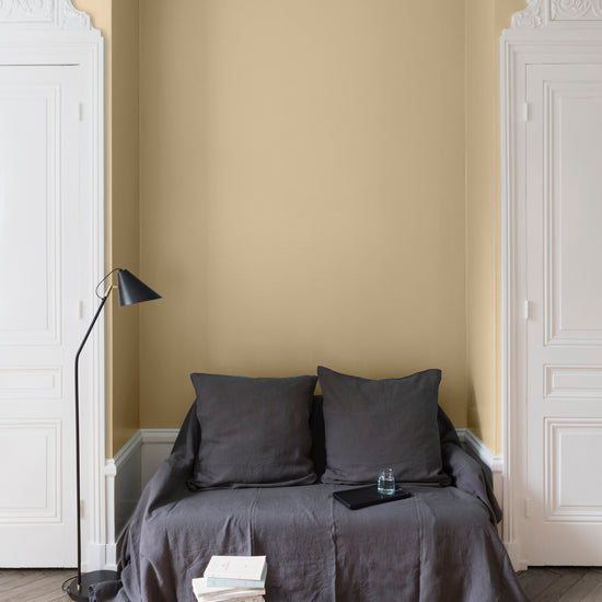 Salon aux murs Peau de Chamois, Velours de Peinture Libéron, avec canapé gris, portes blanches et parquet clair.
