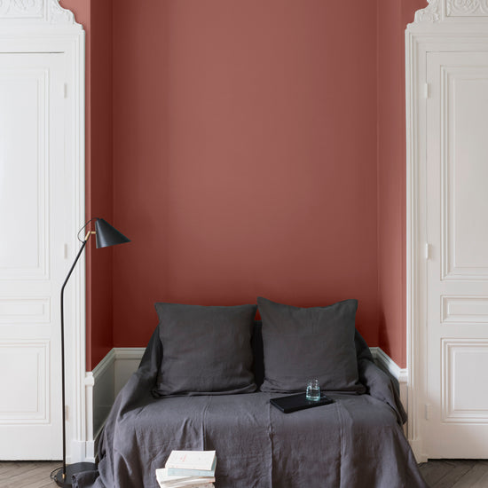 Salon aux murs roses, peinture Velours de Peinture Praliné Rose Libéron avec portes blanches et textiles gris.