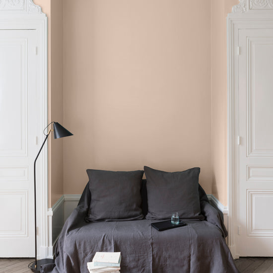 Salon aux murs roses, peinture Velours de Peinture Rose Pompenette Libéron avec portes blanches et textiles gris.