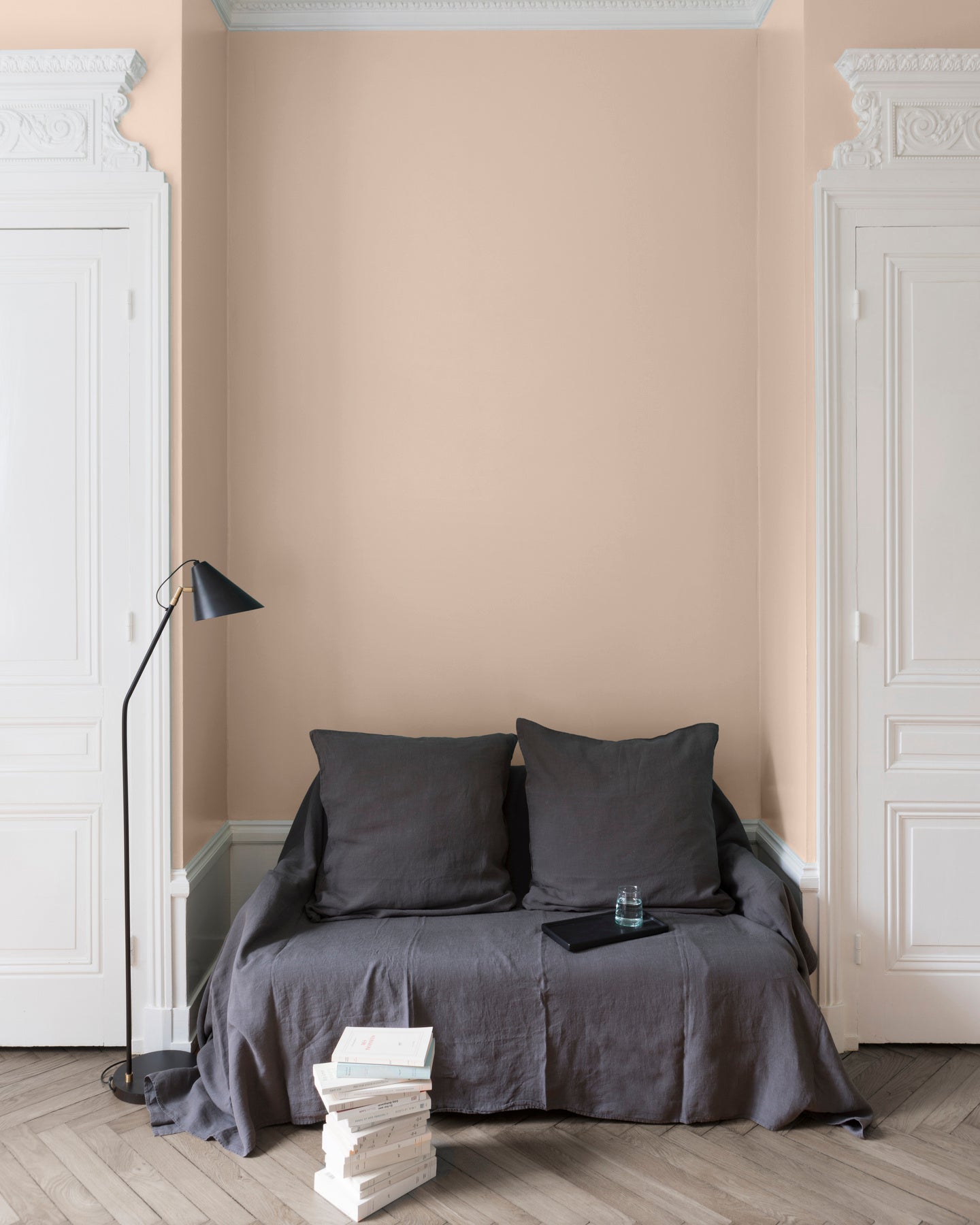 Salon aux murs roses, peinture Velours de Peinture Rose Pompenette Libéron avec portes blanches et textiles gris.