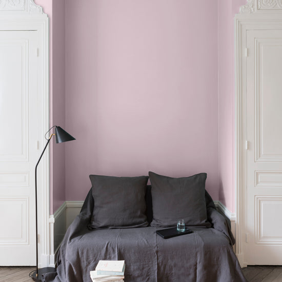 Salon aux murs roses, peinture Velours de Peinture Rose Popeline Libéron avec portes blanches et textiles gris.