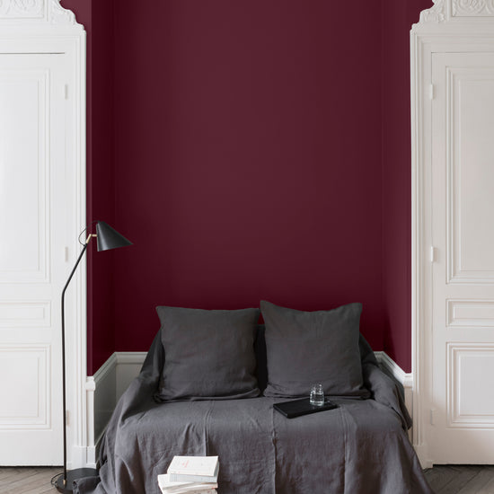 Salon aux murs Rouge Cardinal, Velours de Peinture Libéron, avec canapé gris, portes blanches et parquet clair.