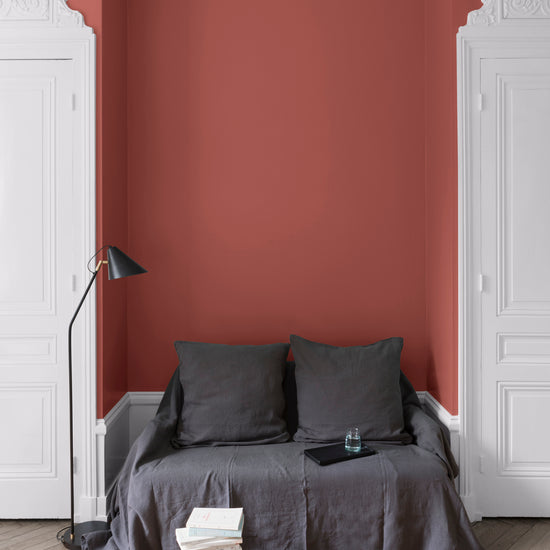 Salon aux murs rouges, peinture Velours de Peinture Rouge de Bourgogne Libéron avec portes blanches et textiles gris.